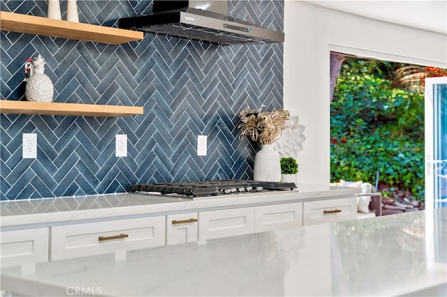 kitchen featuring tasteful backsplash, stainless steel gas cooktop, and white cabinets