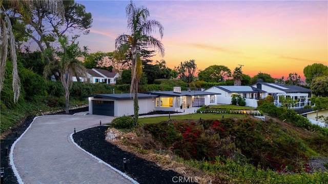 single story home featuring a garage and a yard