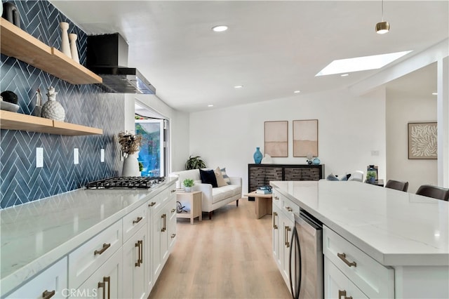 kitchen with white cabinetry, light stone countertops, stainless steel gas cooktop, and tasteful backsplash