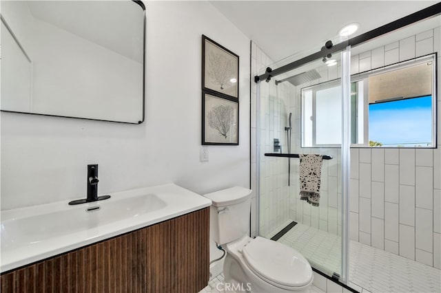 bathroom featuring vanity, a shower with shower door, and toilet