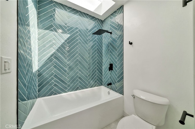 bathroom featuring a skylight, toilet, and tiled shower / bath combo