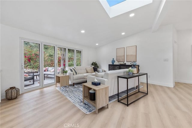 living room featuring vaulted ceiling with skylight and light wood-type flooring