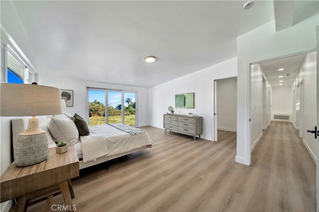 bedroom featuring lofted ceiling and light wood-type flooring