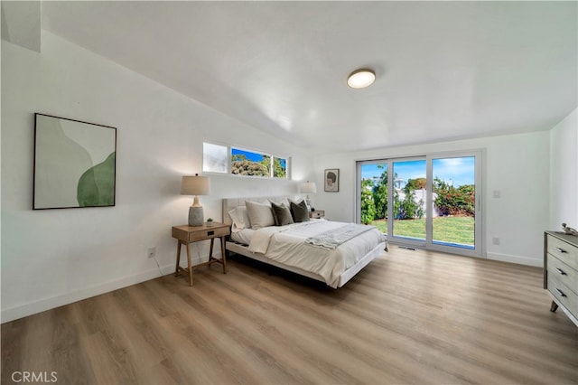 bedroom with access to exterior and hardwood / wood-style floors