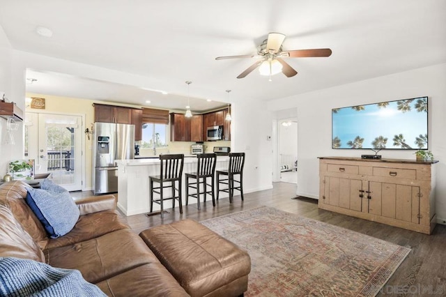 living room with dark wood-type flooring and ceiling fan