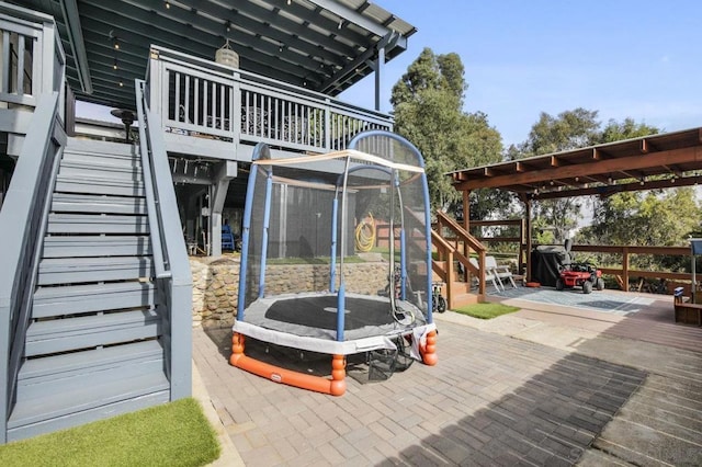 view of patio / terrace featuring a pergola, a deck, and a trampoline