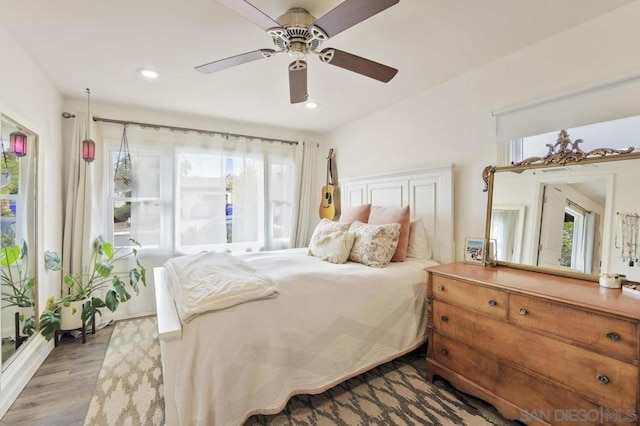 bedroom featuring multiple windows, ceiling fan, and light wood-type flooring