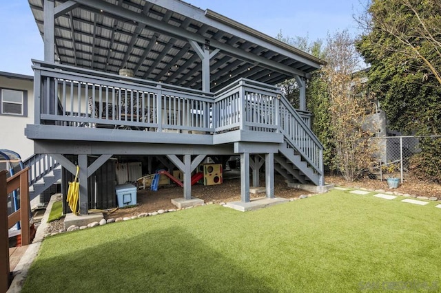 back of property featuring a deck and a lawn