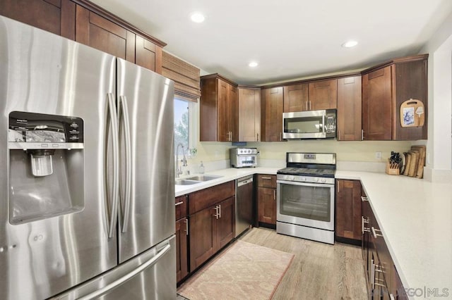 kitchen featuring sink, light hardwood / wood-style floors, and appliances with stainless steel finishes