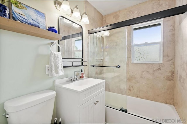 full bathroom featuring toilet, vanity, and shower / bath combination with glass door