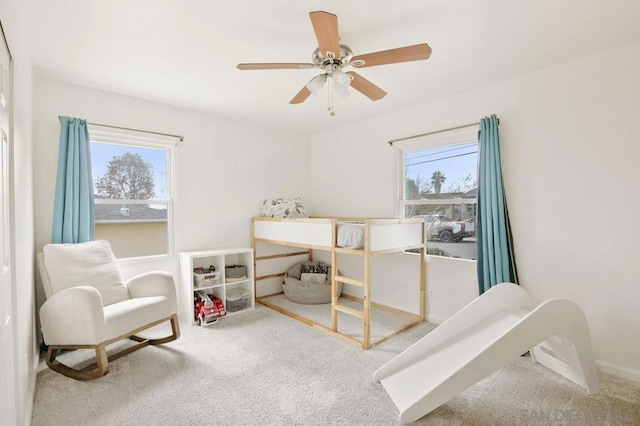 carpeted bedroom featuring multiple windows and ceiling fan