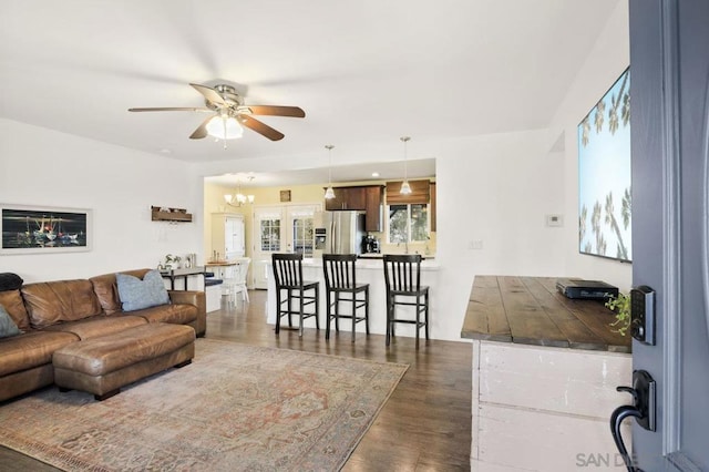 living room with dark hardwood / wood-style floors and ceiling fan with notable chandelier