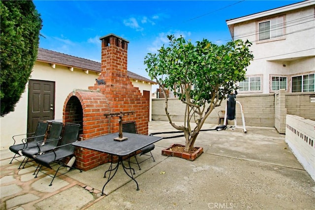 view of patio with an outdoor brick fireplace