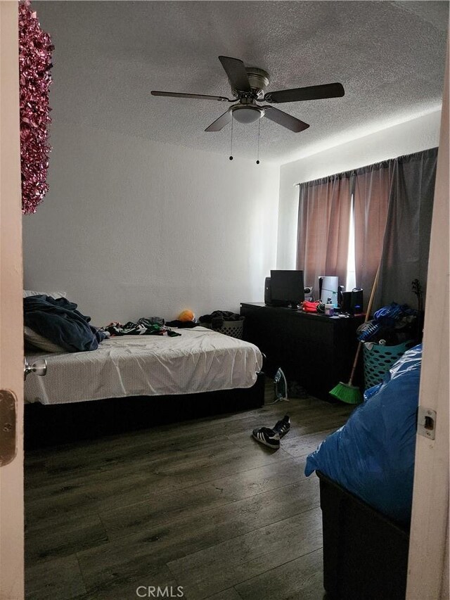 bedroom featuring hardwood / wood-style flooring, ceiling fan, and a textured ceiling