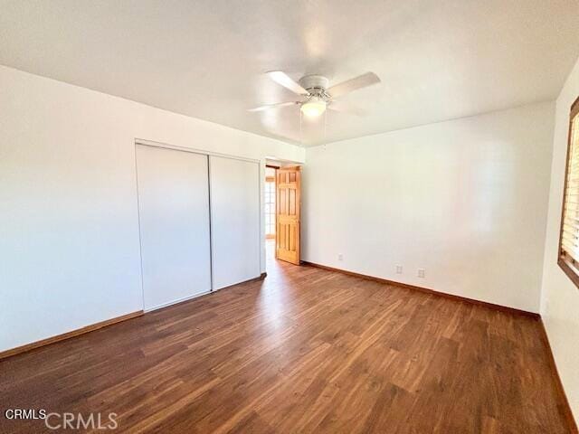 unfurnished bedroom with dark hardwood / wood-style floors, ceiling fan, and a closet