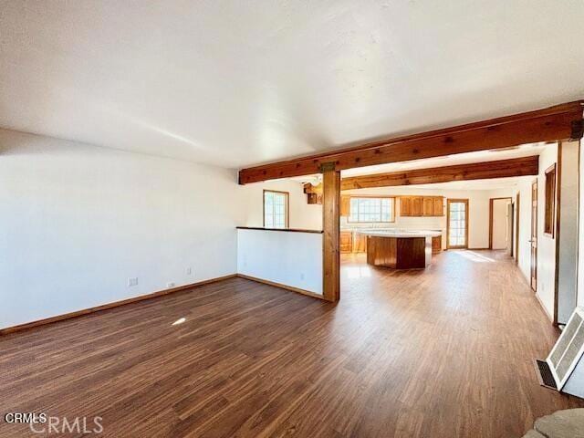 unfurnished living room with beamed ceiling and dark hardwood / wood-style floors