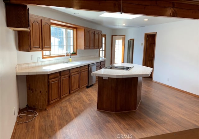 kitchen featuring sink, wood-type flooring, tile countertops, dishwasher, and black electric stovetop