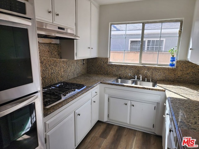 kitchen with white cabinetry, stainless steel appliances, sink, and tasteful backsplash