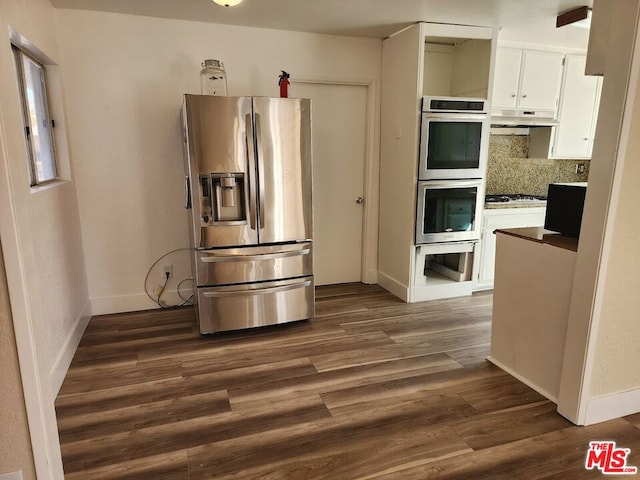 kitchen featuring white cabinetry, stainless steel appliances, dark hardwood / wood-style flooring, and decorative backsplash