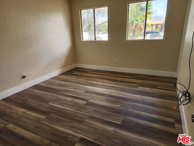 spare room featuring dark wood-type flooring