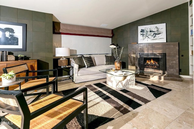 living room with tile walls, a fireplace, and vaulted ceiling