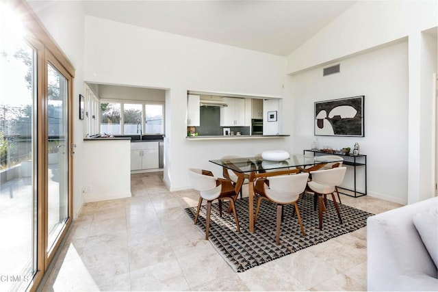 dining room featuring high vaulted ceiling