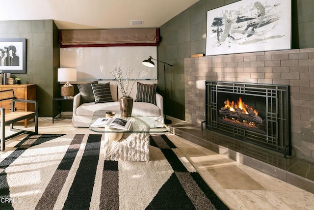 living area featuring tile walls, a fireplace, and vaulted ceiling