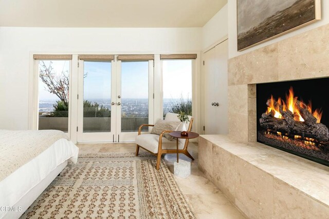 bedroom with multiple windows, a fireplace, and access to outside