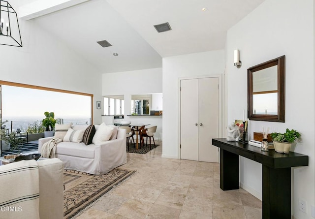 living room featuring visible vents, a wealth of natural light, and high vaulted ceiling