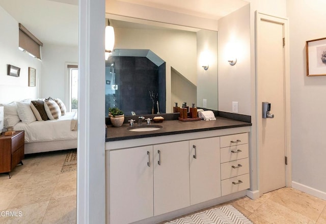 bathroom with connected bathroom, baseboards, vanity, and tile patterned flooring