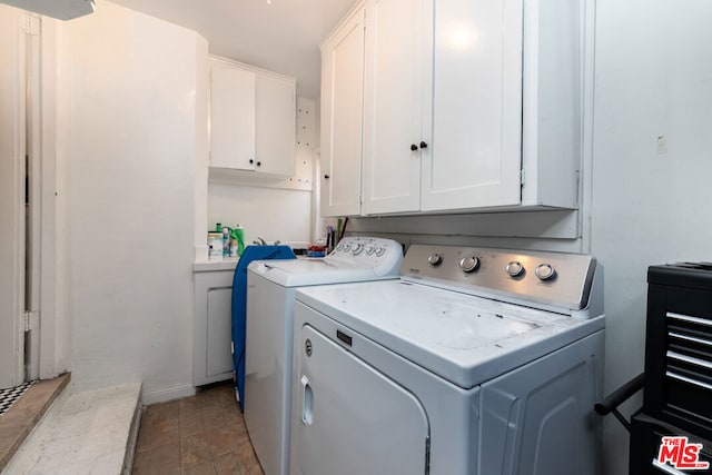 laundry room featuring cabinets and washer and dryer