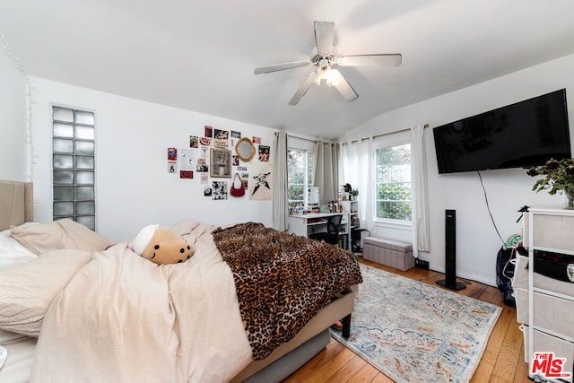 bedroom with hardwood / wood-style flooring, vaulted ceiling, and ceiling fan