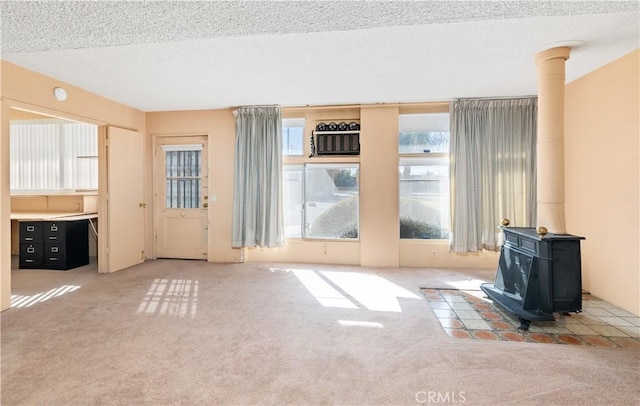 332 E 7th St, San Jacinto, CA 92583 - unfurnished living room featuring carpet, a textured ceiling, and a wood stove