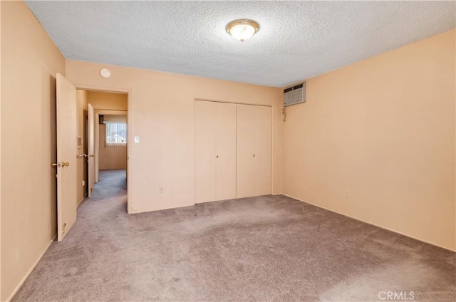 332 E 7th St, San Jacinto, CA 92583 - unfurnished bedroom with an AC wall unit, carpet floors, a closet, and a textured ceiling