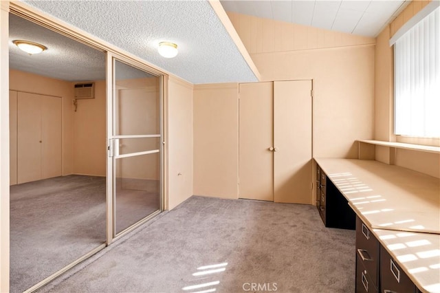 332 E 7th St, San Jacinto, CA 92583 - interior space featuring lofted ceiling, an AC wall unit, a textured ceiling, light carpet, and a closet