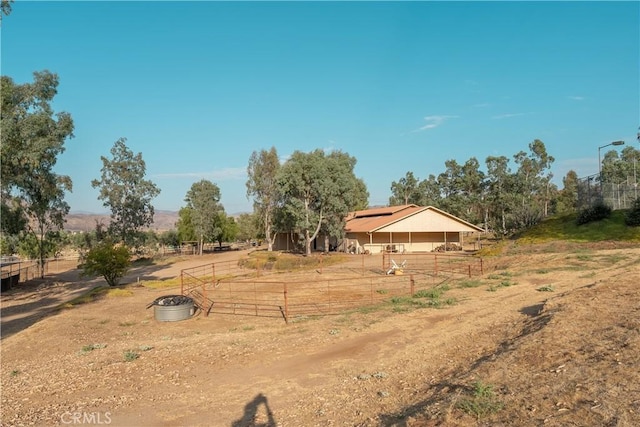 view of yard with a fire pit, a rural view, and fence