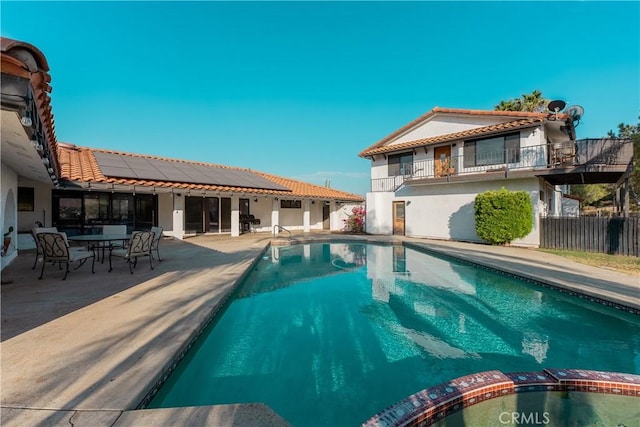 view of pool with a pool with connected hot tub, a patio area, and fence