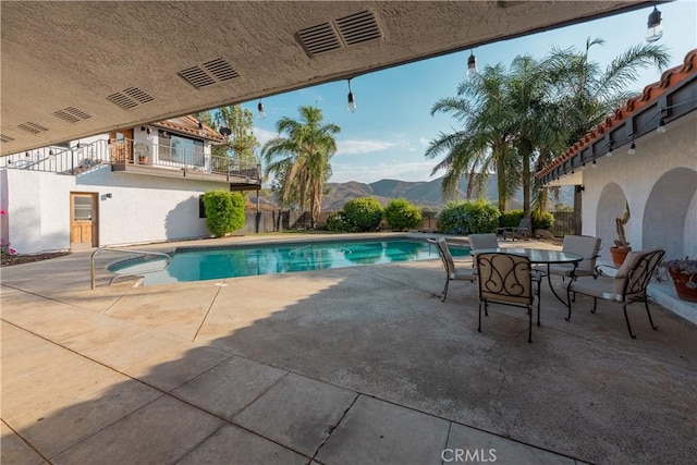 view of pool featuring a fenced in pool, a mountain view, and a patio