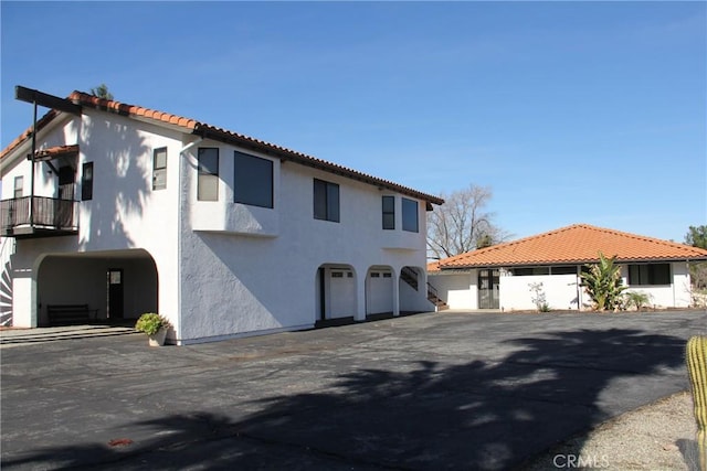 view of front facade featuring driveway, an attached garage, and stucco siding