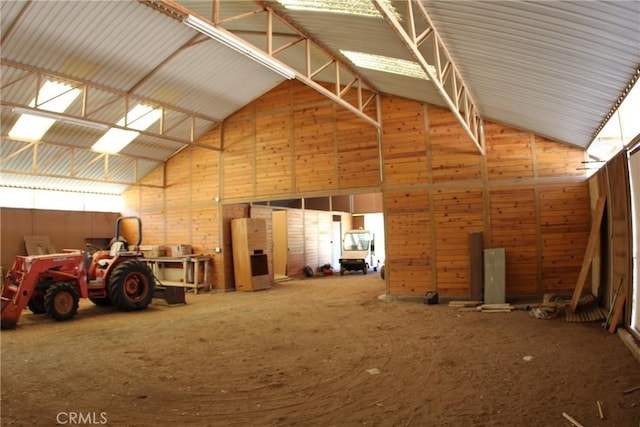 interior space featuring lofted ceiling and metal wall