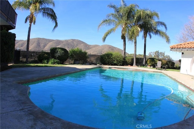 view of swimming pool with a fenced backyard, a mountain view, a fenced in pool, and a patio