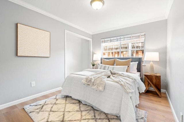 bedroom featuring ornamental molding, light hardwood / wood-style floors, and a closet