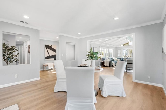 dining area featuring ornamental molding, vaulted ceiling, and light wood-type flooring