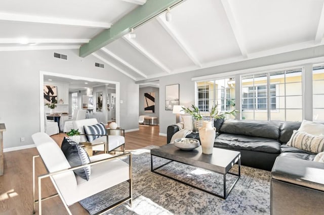 living room featuring hardwood / wood-style floors, lofted ceiling with beams, and rail lighting