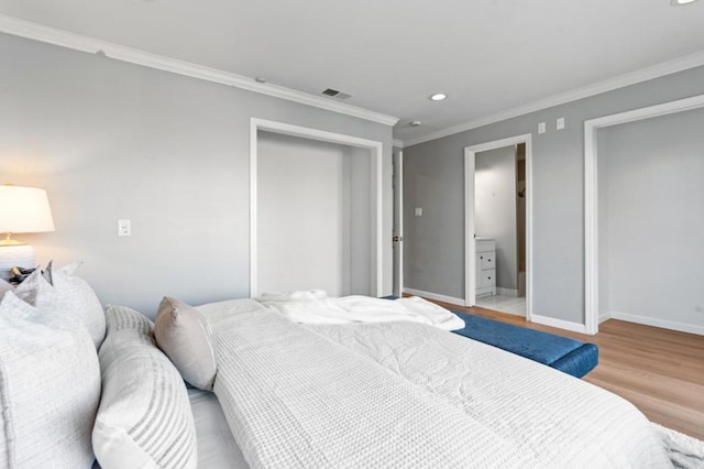 bedroom featuring ornamental molding and light hardwood / wood-style flooring