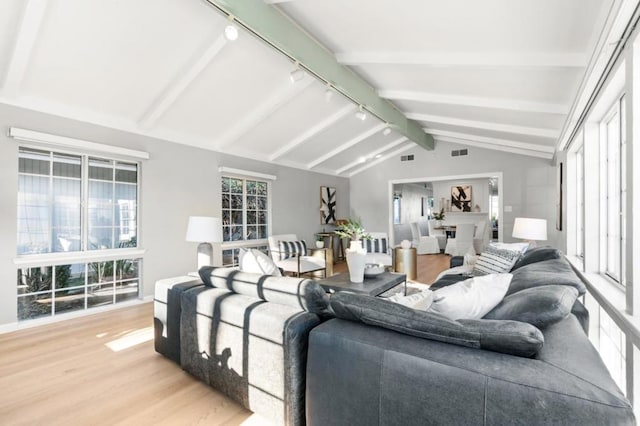 living room featuring wood-type flooring and lofted ceiling with beams