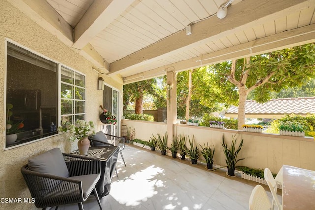 sunroom with beamed ceiling and plenty of natural light