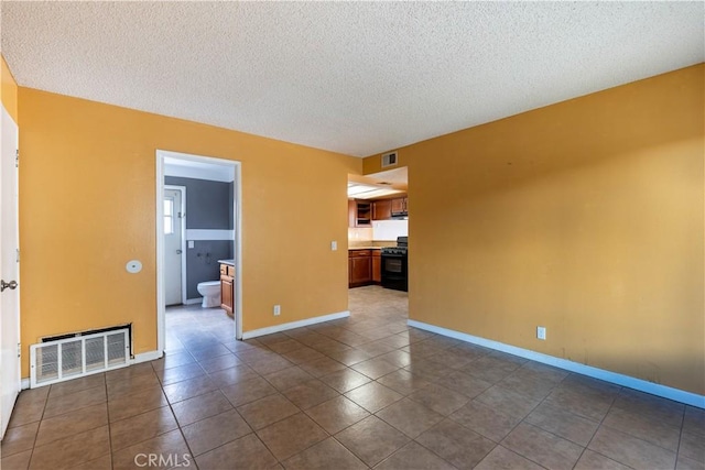 tiled empty room with a textured ceiling