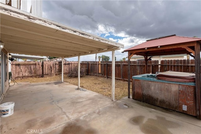 view of patio / terrace featuring a hot tub and a gazebo