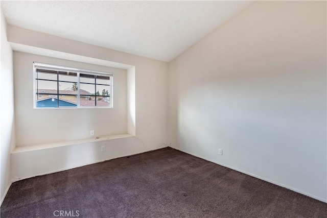 carpeted spare room with lofted ceiling